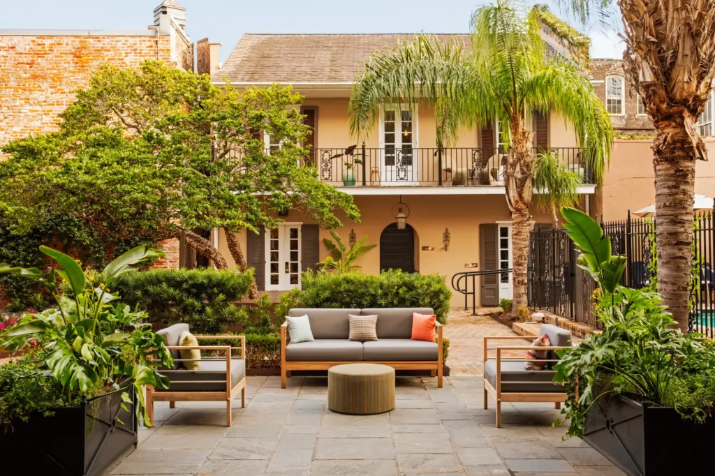 a patio with a couch, chairs and a table