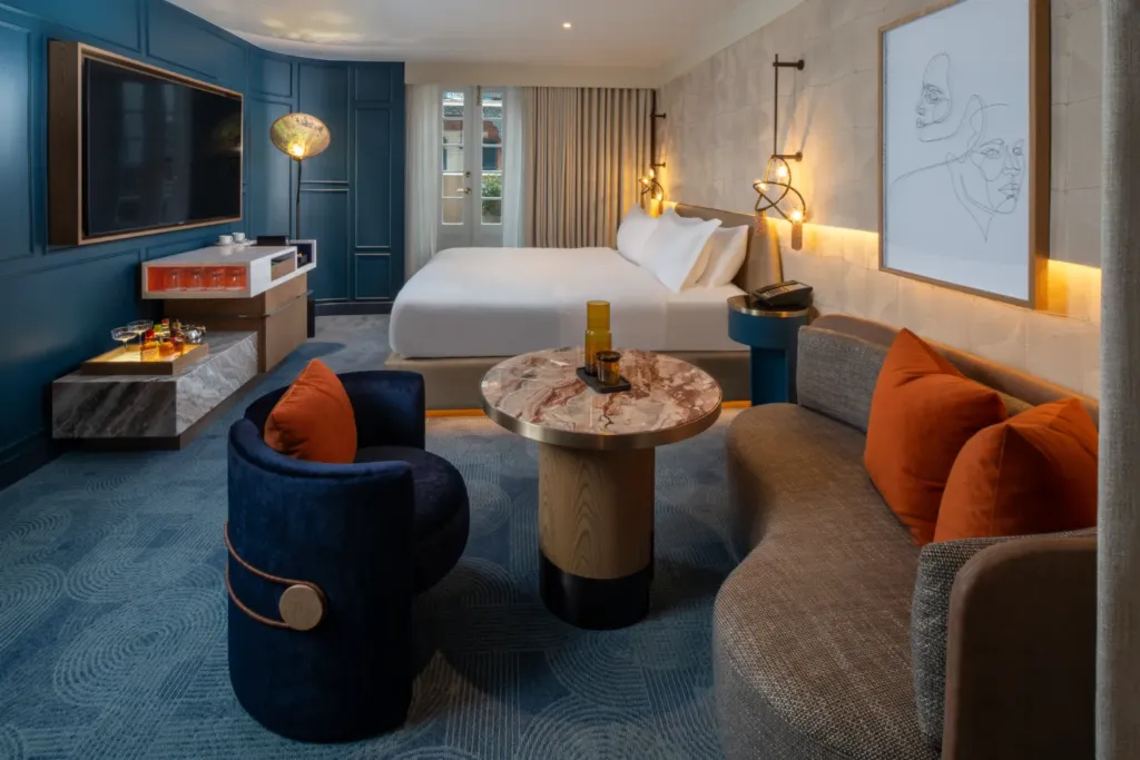 a hotel room with a bed, couch, and a tv