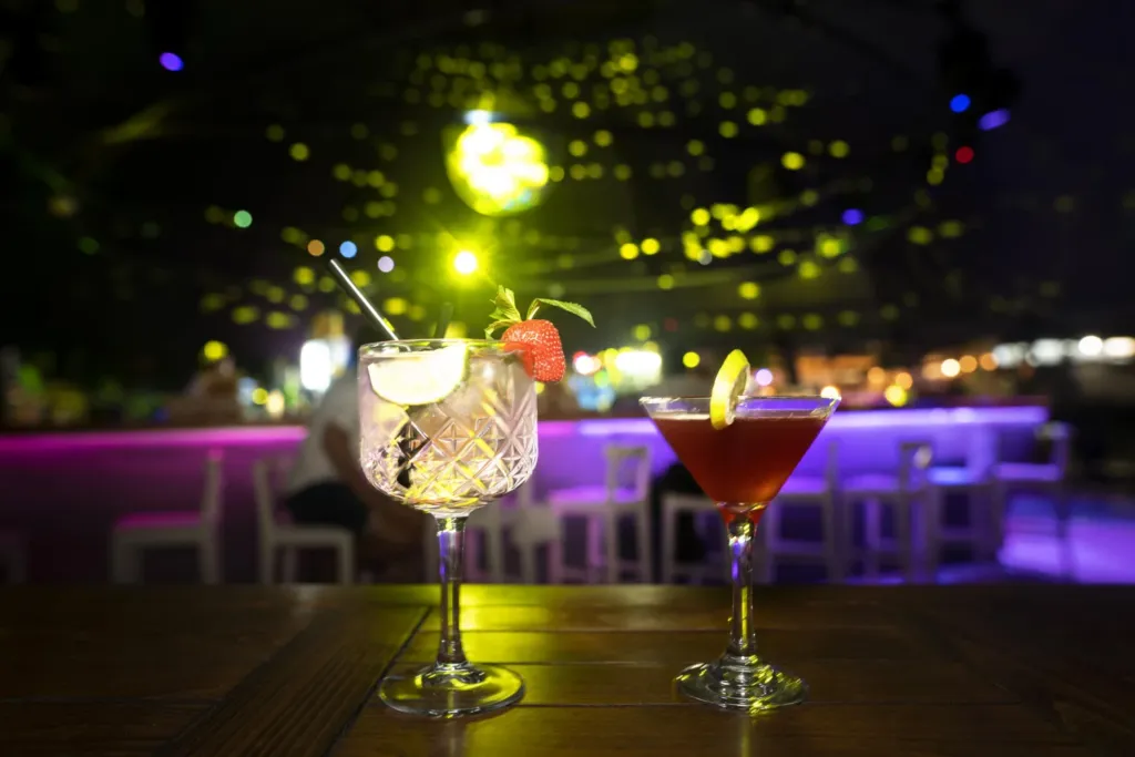 two cocktails sitting on top of a wooden table