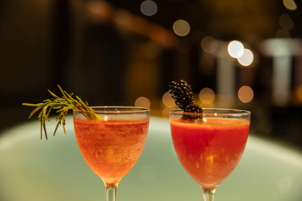 a couple of glasses that have some drinks in them